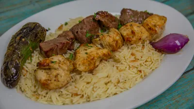 Grilled chicken and beef kabob skewers with rice pilaf and grilled vegetables at Yanni's Gyros