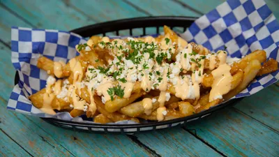 Crispy garlic feta fries topped with herbs and feta cheese at Yanni's Gyros