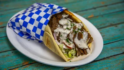 Traditional beef shawarma pita with fresh vegetables and tahini sauce at Yanni's Gyros